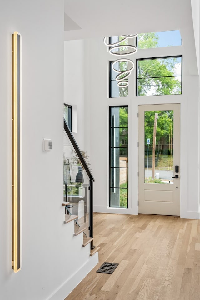 entryway with light hardwood / wood-style floors and a notable chandelier