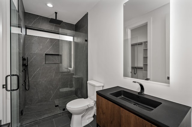 bathroom featuring vanity, a shower with shower door, toilet, and tile patterned flooring