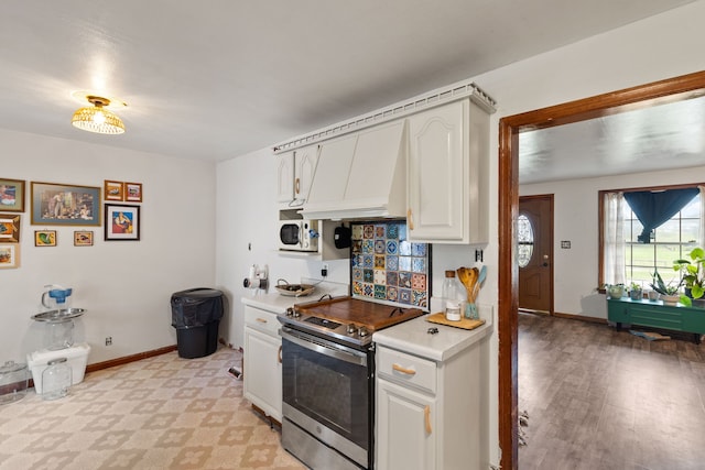 kitchen with light hardwood / wood-style floors, electric stove, custom exhaust hood, and white cabinets