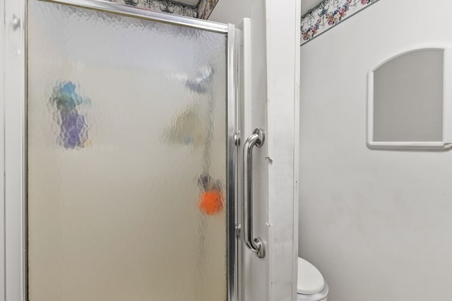 bathroom with an enclosed shower and toilet