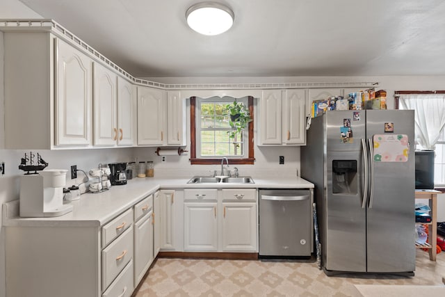 kitchen with appliances with stainless steel finishes, sink, and white cabinets