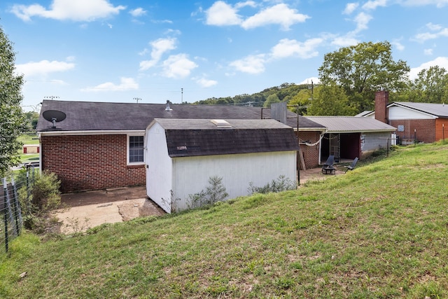 rear view of property with a lawn and a shed