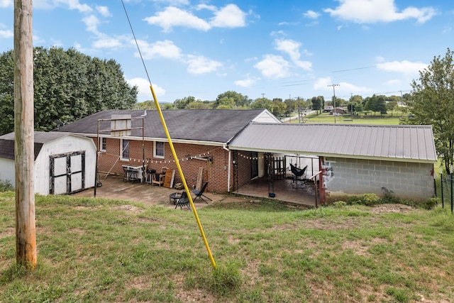 rear view of property featuring a shed, a lawn, and a patio area