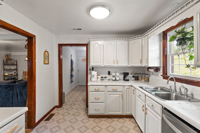 kitchen featuring white cabinets, dishwasher, and sink