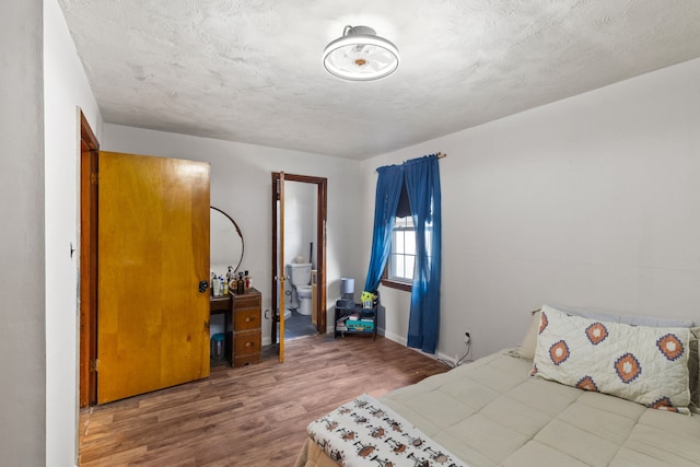 bedroom with hardwood / wood-style flooring and a textured ceiling