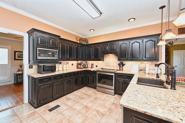 kitchen with hanging light fixtures, sink, stainless steel appliances, light stone countertops, and crown molding