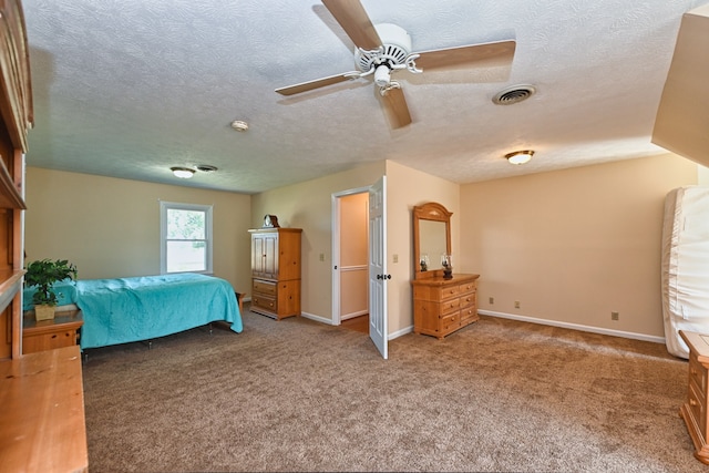 bedroom with ceiling fan, a textured ceiling, and carpet flooring