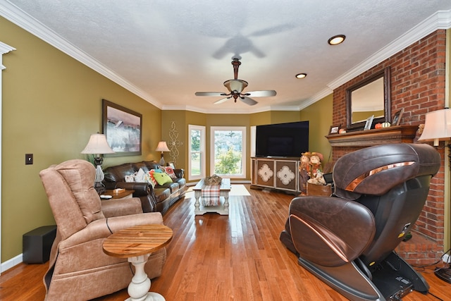 living room with light wood-type flooring, a textured ceiling, ornamental molding, and ceiling fan