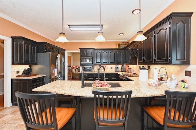 kitchen with tasteful backsplash, sink, hanging light fixtures, appliances with stainless steel finishes, and crown molding