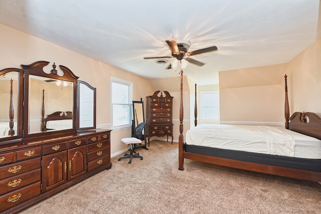 bedroom featuring a textured ceiling, light carpet, and ceiling fan