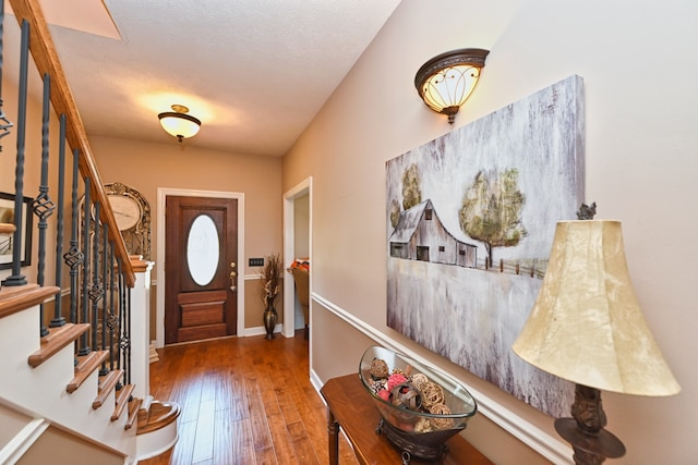 entryway with a textured ceiling and dark hardwood / wood-style flooring