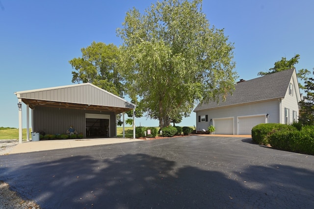 view of front of home with a garage and an outbuilding