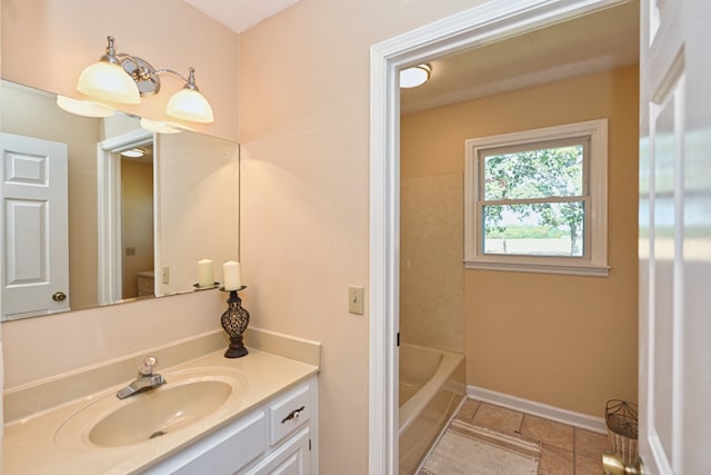 bathroom with vanity, tile patterned floors, toilet, and a tub