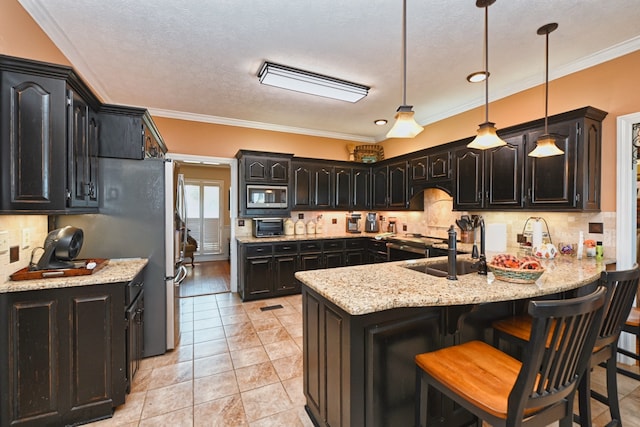 kitchen featuring decorative backsplash, stainless steel microwave, ornamental molding, and decorative light fixtures