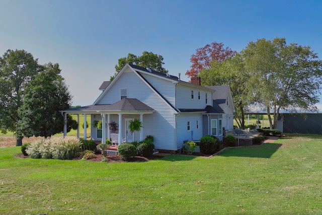 back of house featuring a porch and a yard