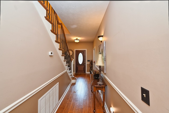 entryway featuring a textured ceiling and dark hardwood / wood-style flooring