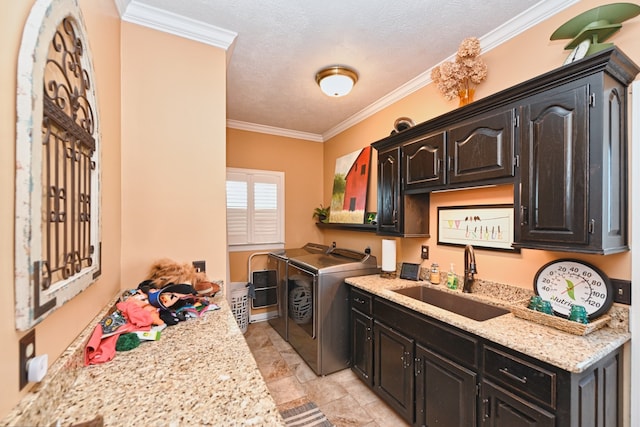 kitchen with ornamental molding, sink, and washing machine and clothes dryer