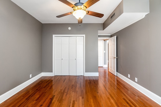 unfurnished bedroom with ceiling fan, hardwood / wood-style flooring, and a closet