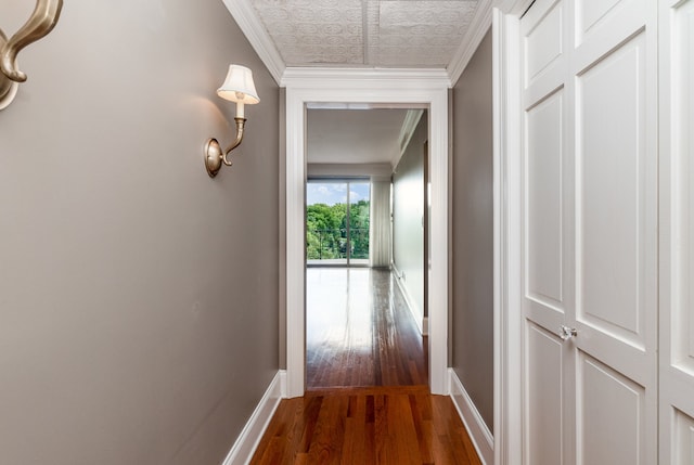 hallway with ornamental molding and dark hardwood / wood-style flooring