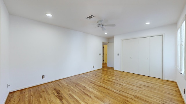 unfurnished bedroom with a closet, light hardwood / wood-style floors, and ceiling fan