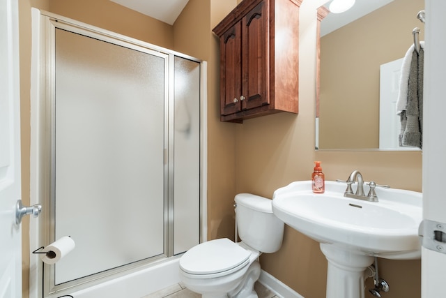 bathroom featuring toilet and a shower with door