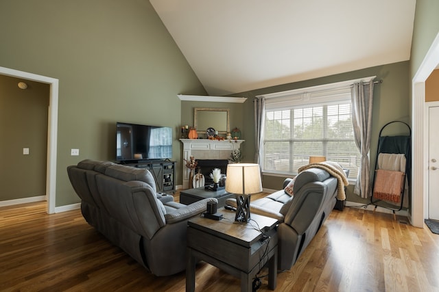 living room featuring light hardwood / wood-style floors and high vaulted ceiling