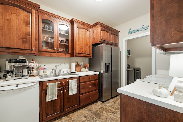 kitchen with dishwasher, stainless steel fridge, washing machine and dryer, and sink