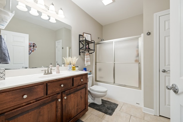 full bathroom with toilet, vanity, tile patterned floors, and enclosed tub / shower combo