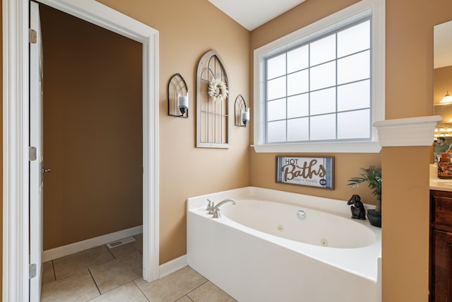 bathroom with tile patterned floors, a bathtub, and vanity