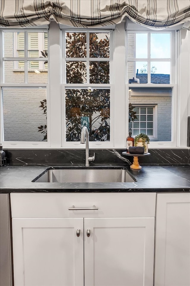 bar featuring white cabinetry and sink