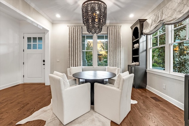 dining area with a notable chandelier, dark hardwood / wood-style floors, and crown molding