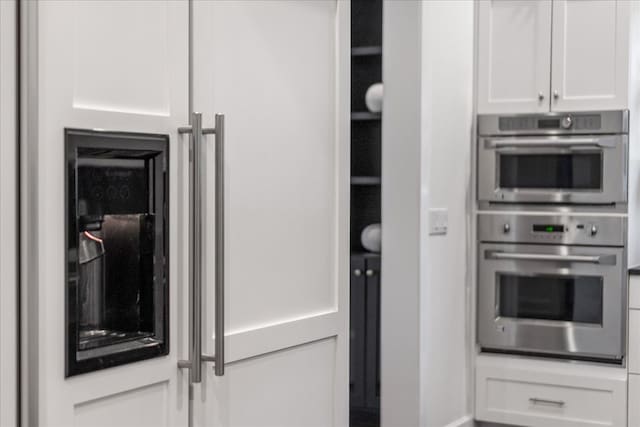 kitchen with double oven and white cabinetry