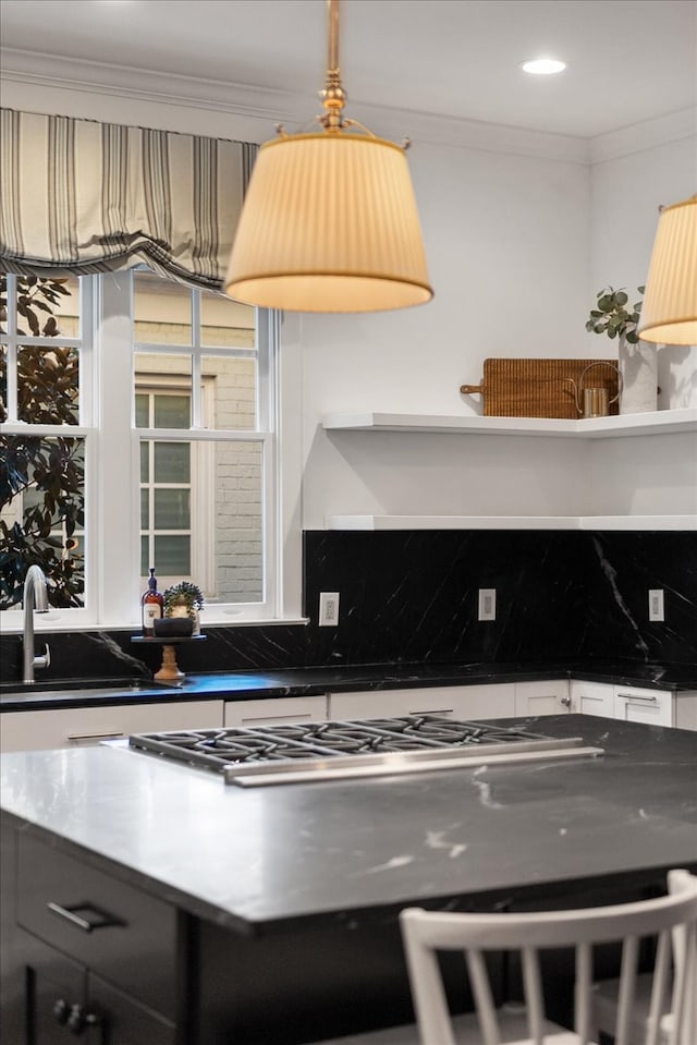 kitchen featuring decorative backsplash, ornamental molding, and sink