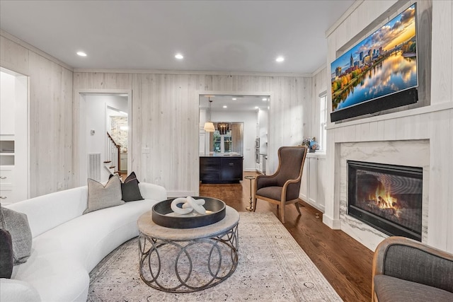 living room with a fireplace, ornamental molding, dark wood-type flooring, and a healthy amount of sunlight