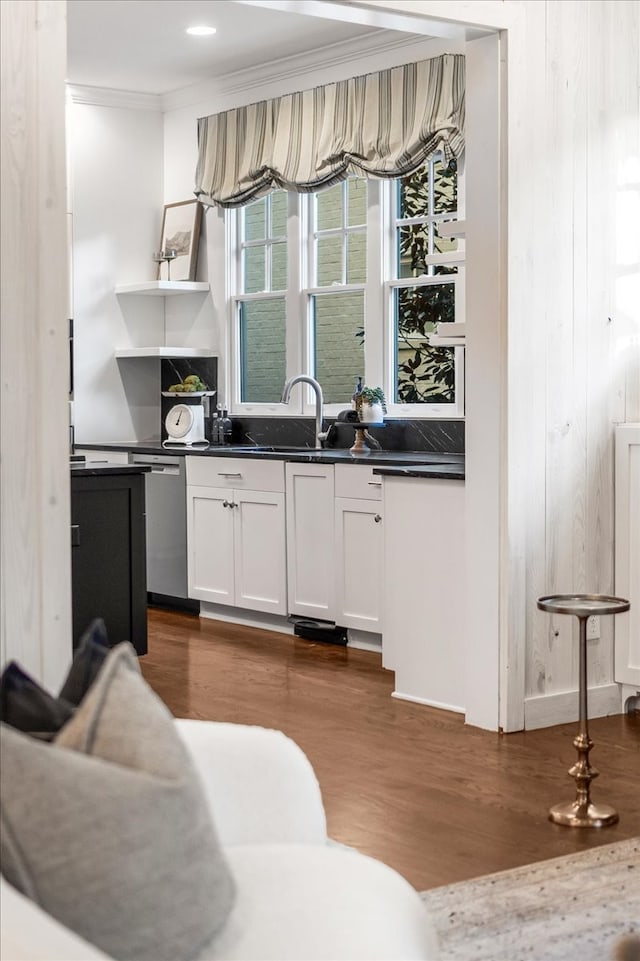 bar with white cabinetry, sink, dark wood-type flooring, stainless steel dishwasher, and ornamental molding