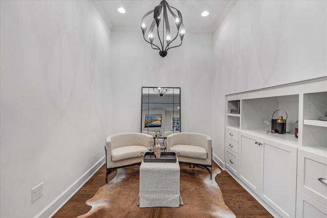 sitting room featuring crown molding, dark wood-type flooring, and an inviting chandelier