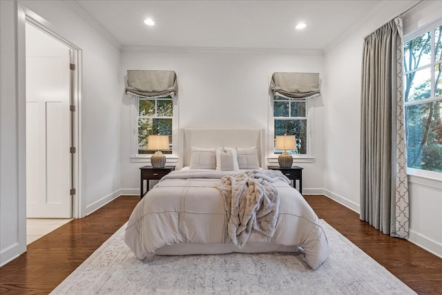 bedroom featuring hardwood / wood-style floors, multiple windows, and crown molding