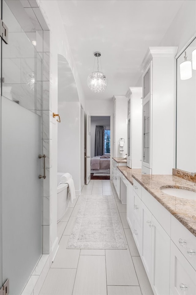 bathroom featuring tile patterned flooring, vanity, a shower with door, and a chandelier