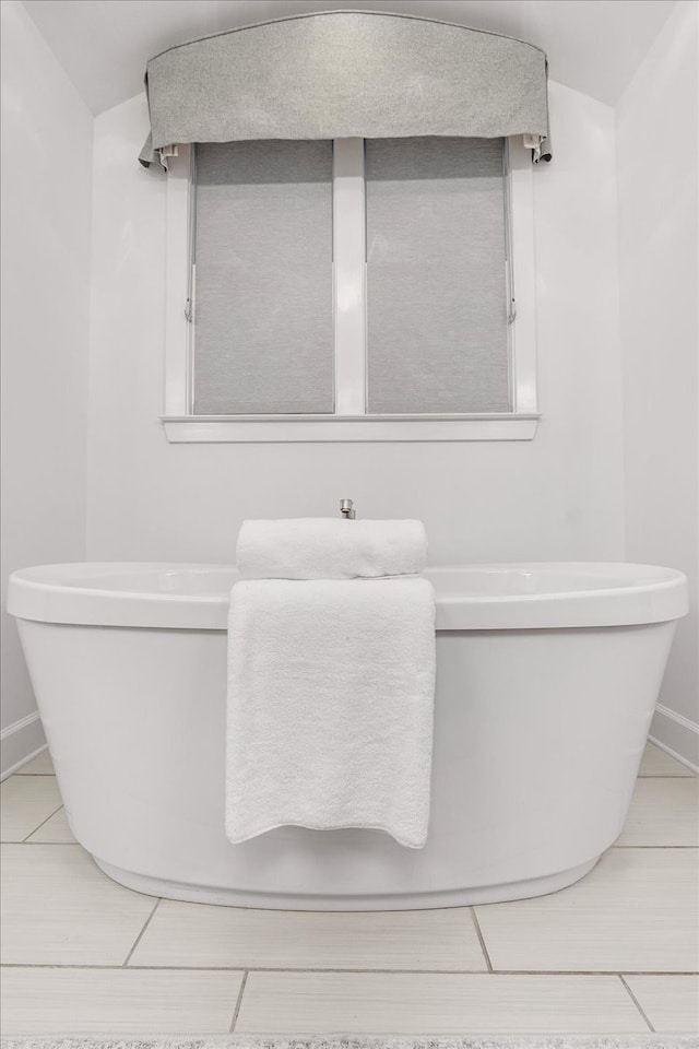 bathroom with tile patterned floors and a bathing tub