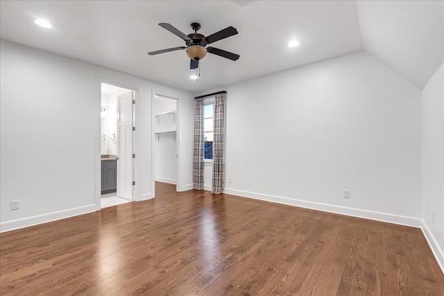 unfurnished bedroom with dark hardwood / wood-style flooring, a walk in closet, ensuite bath, ceiling fan, and a closet