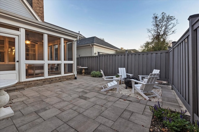 patio terrace at dusk with a sunroom and an outdoor fire pit