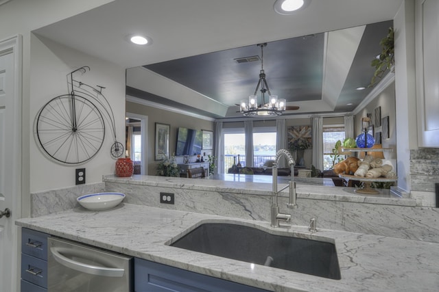 kitchen featuring blue cabinets, a tray ceiling, a notable chandelier, sink, and dishwasher