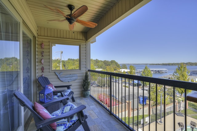 balcony featuring a water view and ceiling fan