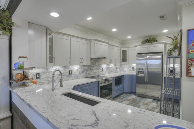 kitchen with ornamental molding, light stone countertops, stainless steel appliances, and white cabinets