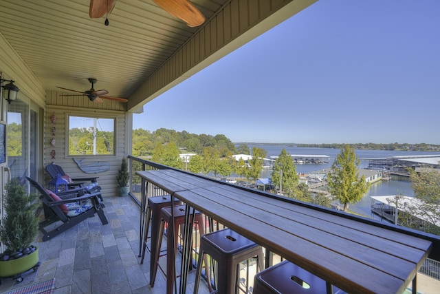 balcony with a water view and ceiling fan