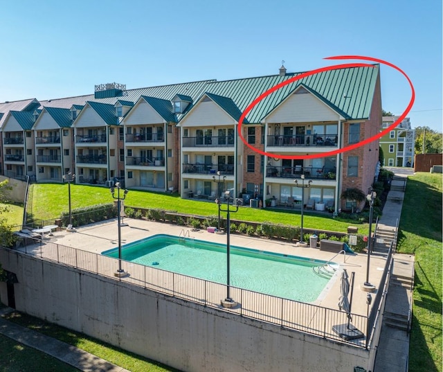 view of pool with a lawn