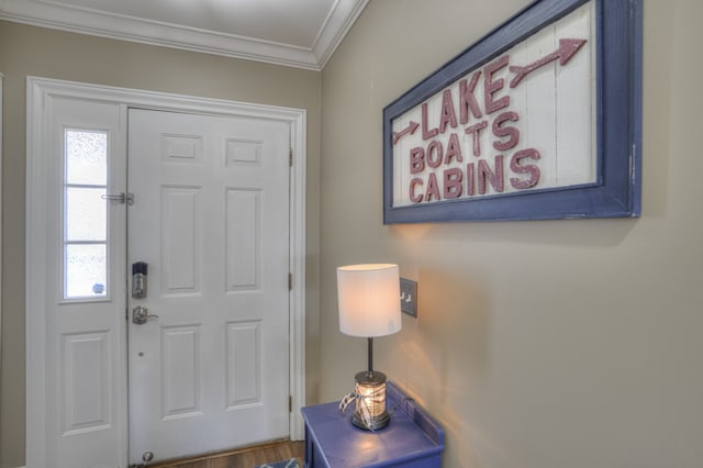 foyer entrance with crown molding and hardwood / wood-style floors