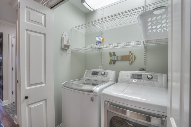 laundry area with crown molding, independent washer and dryer, and hardwood / wood-style floors