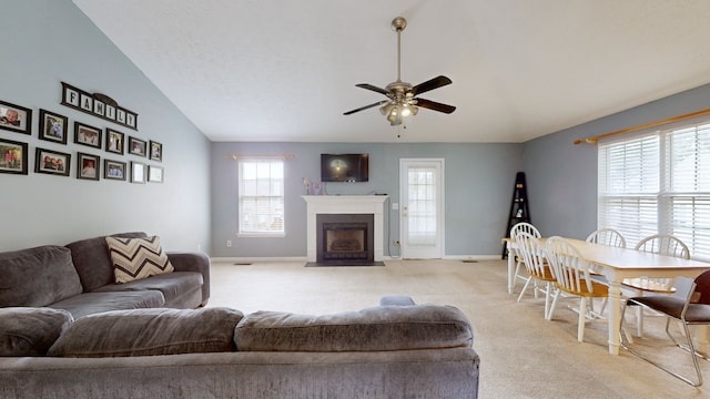 carpeted living room with vaulted ceiling, ceiling fan, and a wealth of natural light