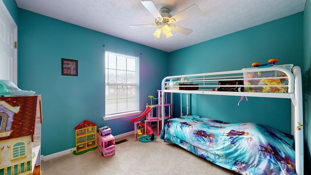 carpeted bedroom featuring ceiling fan and a textured ceiling